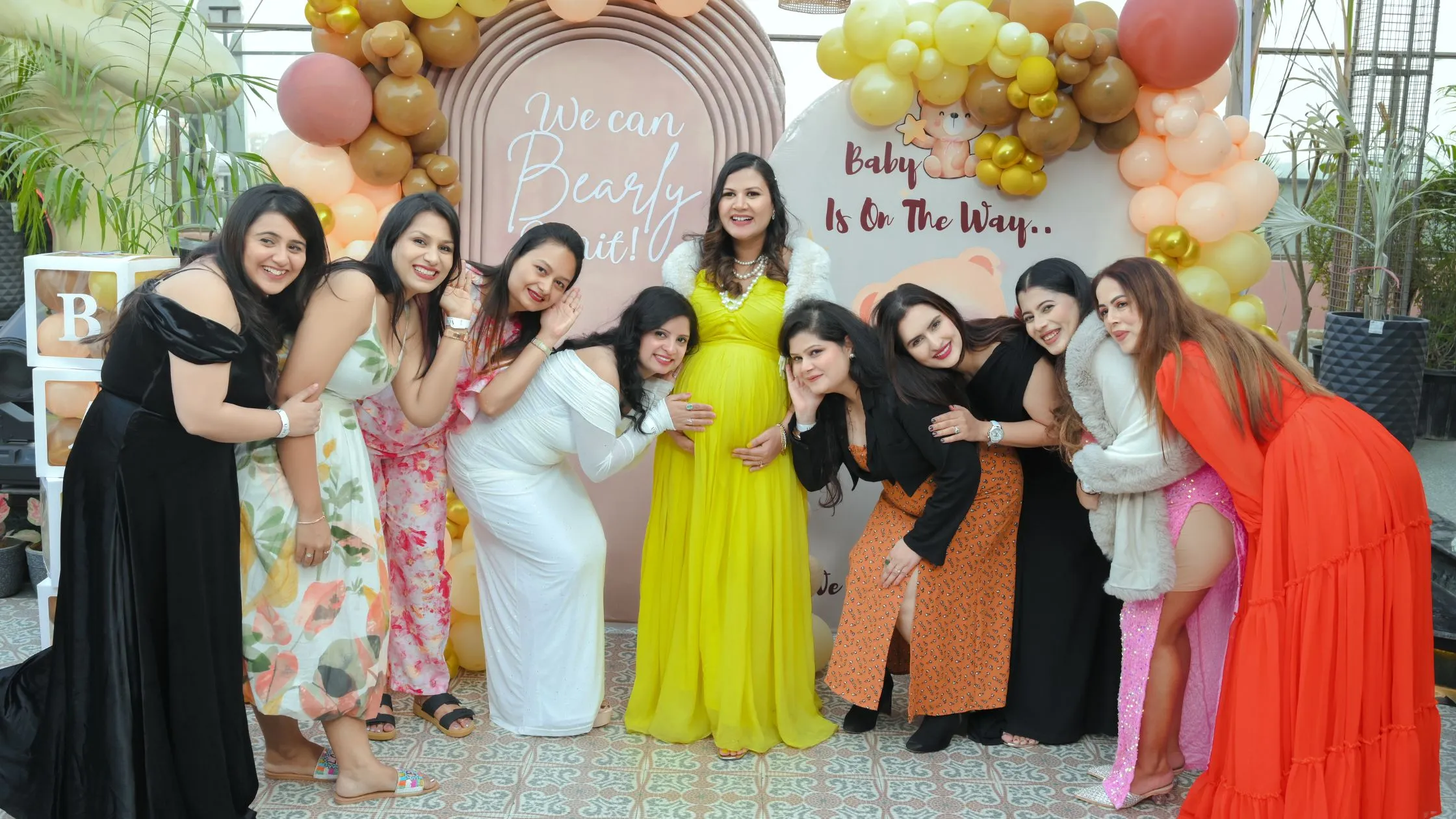 Candid baby shower photography featuring friends gathered around the expecting mother, celebrating pregnancy with love and excitement.