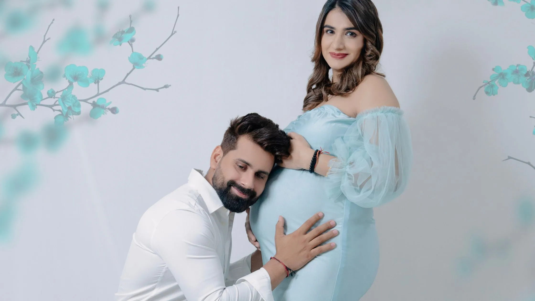 Beautiful maternity photoshoot by Indo Frames with couple posing in elegant blue outfit.