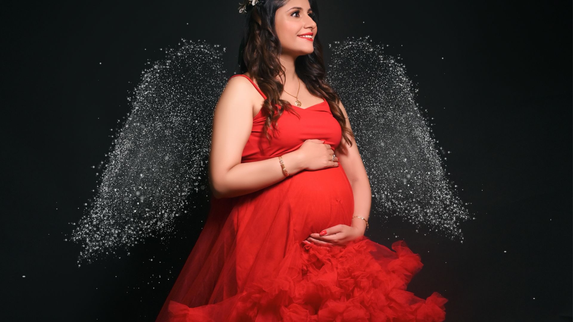 Glowing pregnant woman in red tulle dress with angel wing sparkle effect — maternity photoshoot captions for Instagram by Indo Frames