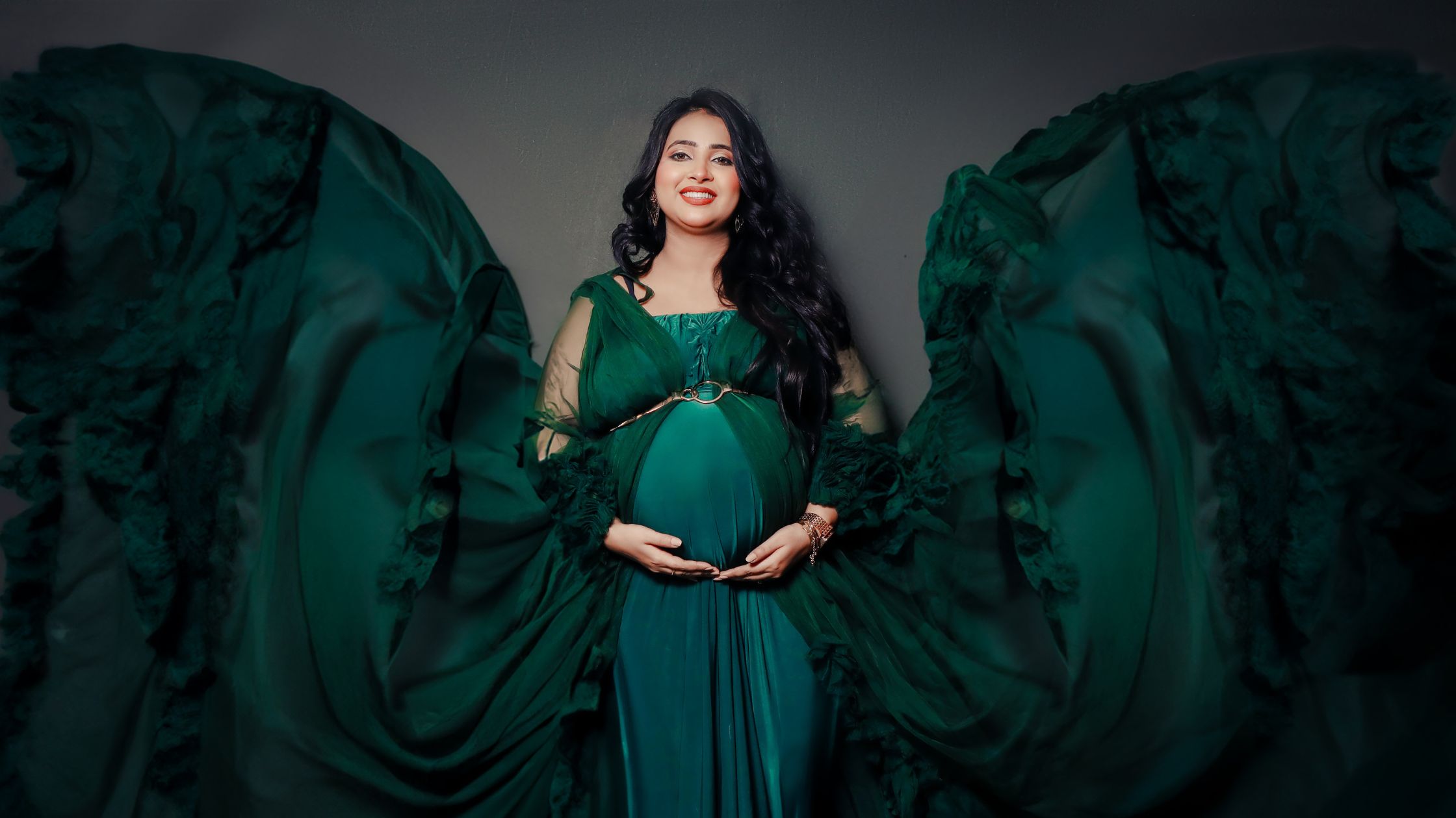 Beautiful maternity photoshoot portrait in green gown by Indo Frames photography.
